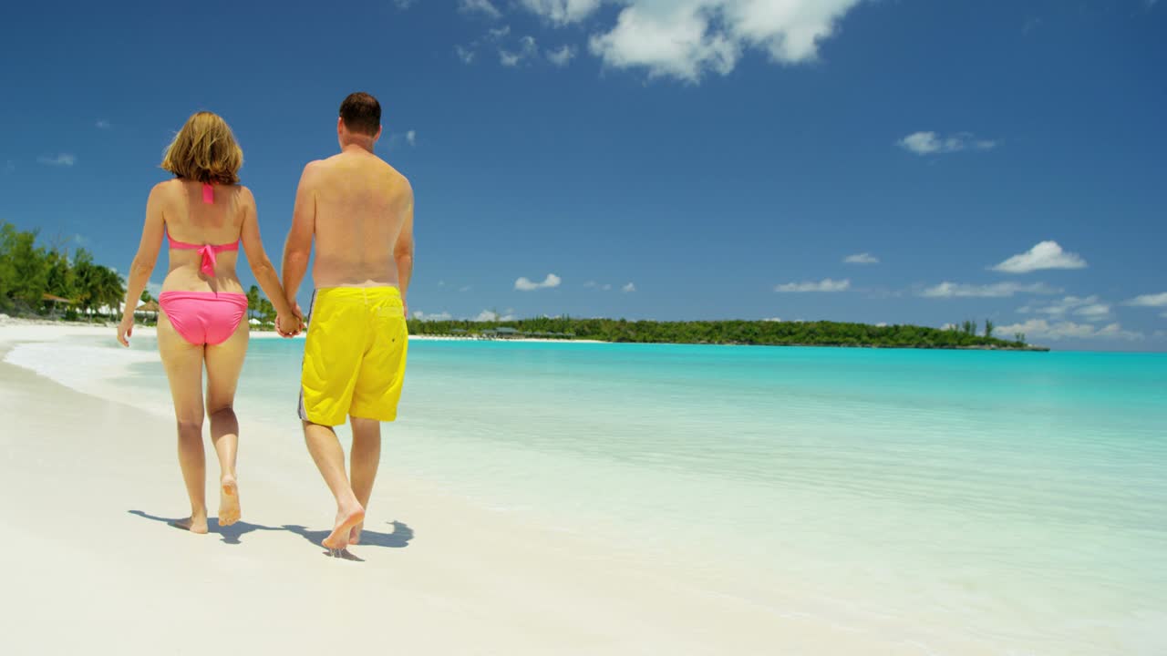 una pareja caucásica en trajes de baño en vacaciones de lujo en la playa.