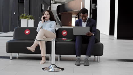 two people sitting in business center hall