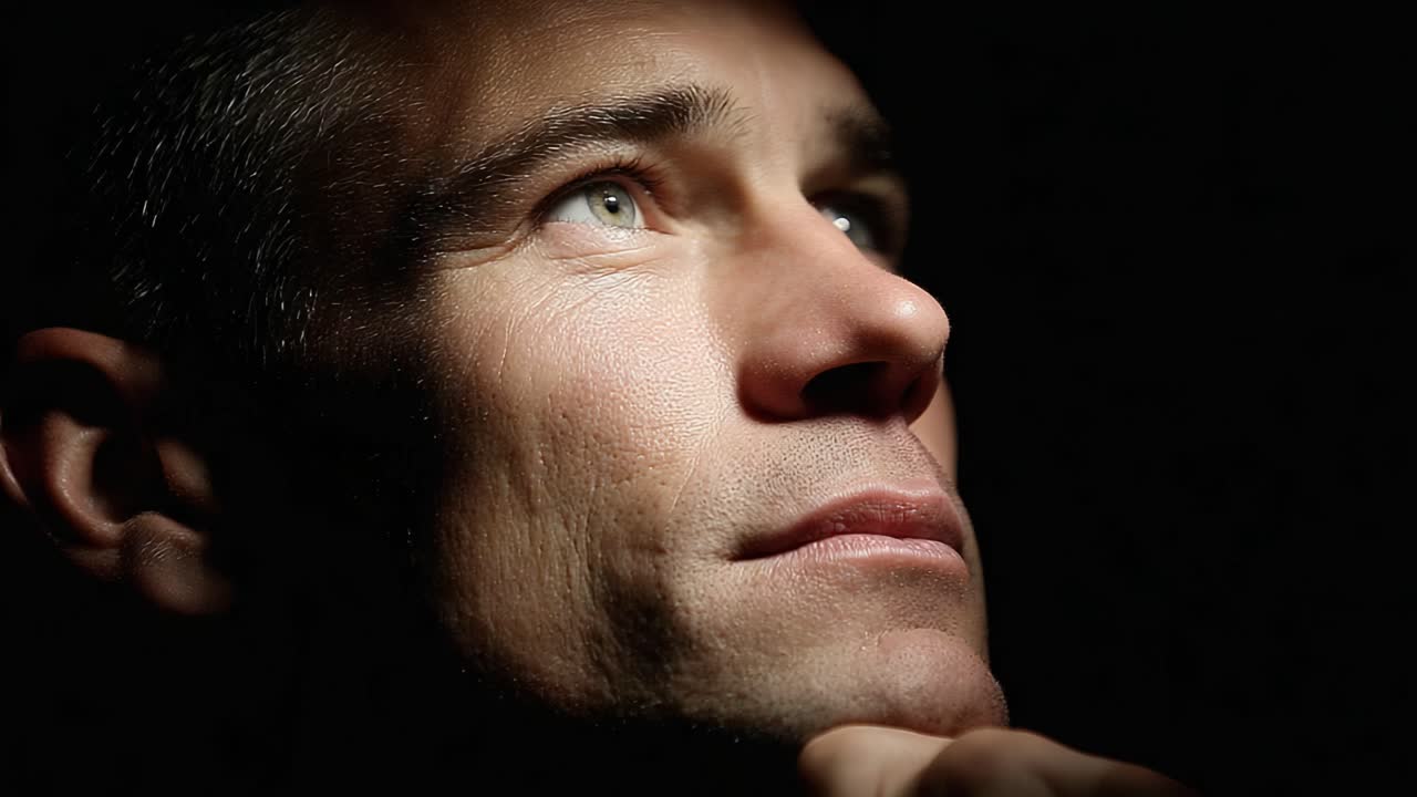 A Thoughtful Man Contemplating Life's Mysteries, Bathed in Dramatic Shadow and Light from the Side, Evoking Deep Emotions and Reflection in His Expression