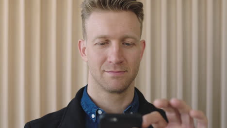 close up portrait of attractive caucasian man looking pensive texting browsing using smartphone mobile young male entrepreneur networking