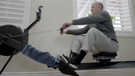 Senior-overweight-man-working-out-on-a-rowing-machine---low-angle-sliding