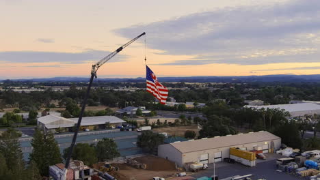 Amerikanische-Flagge,-Die-Am-4.-Juli-Bei-Sonnenuntergang-In-Windsor,-Kalifornien,-Usa-An-Einem-Kran-Hängt