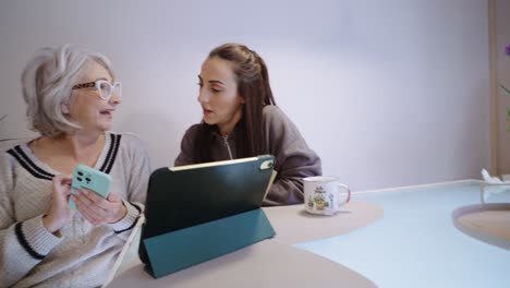 two women using technology at a table