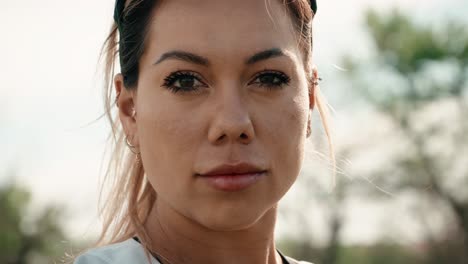 a dramatic close up of a beautiful female athlete in a jersey giving a strong competitive stare into the camera producing an epic atmosphere