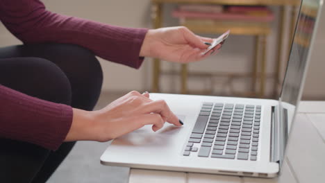 primer plano en cámara lenta de una joven que usa una laptop para hacer una compra en línea