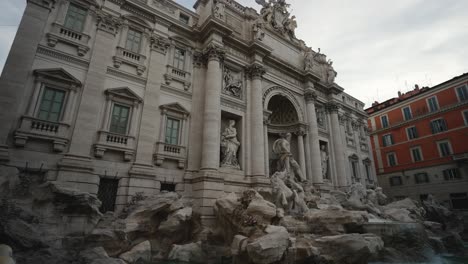 Toma-Panorámica-Inclinada-Hacia-Abajo-Y-Hacia-La-Derecha-Filmando-La-Fontana-De-Trevi-En-Roma,-Italia-En-4k