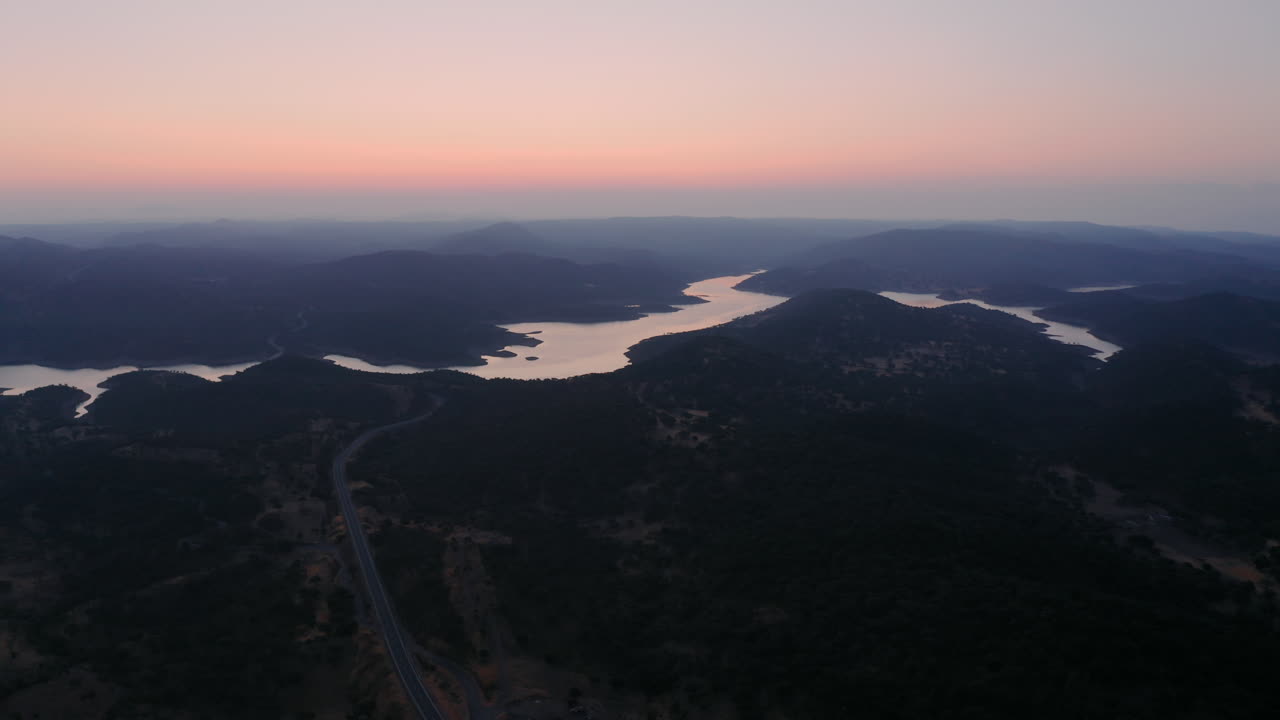 hermosa foto de un dron de un gran río que atraviesa un paisaje montañoso durante el amanecer