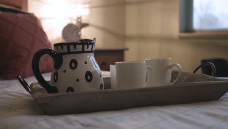 Pull-back-slider-shot-of-a-tea-set-sitting-on-a-bed-in-a-bedroom