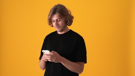 smiling blond man texting by phone