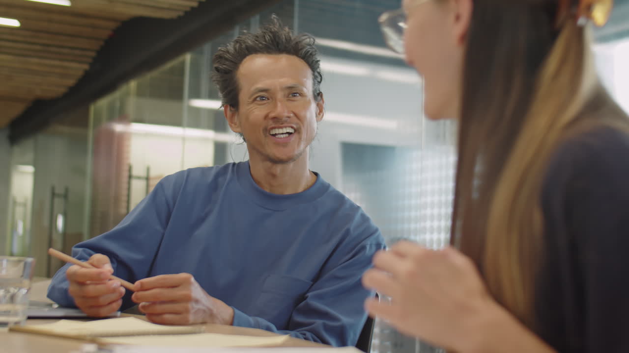 Uomo che parla di lavoro con una collega in uno spazio di coworking