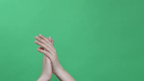 manos haciendo algunas figuras simbólicas en la llave de croma verde