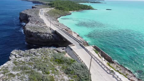 cinematic aerial view drone shot flying over glass window bridge on the island of eleuthera in the bahamas - separating the atlantic ocean from the caribbean sea