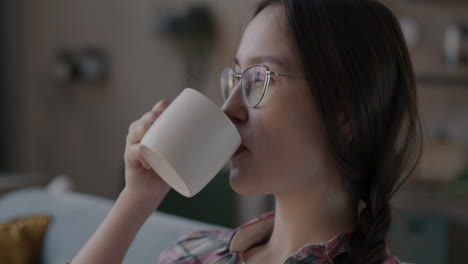 집 에서 뜨거운 음료 를 마시고 있는 여자