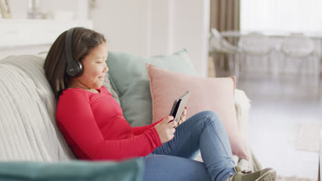 video of happy asian girl resting on sofa with smartphone