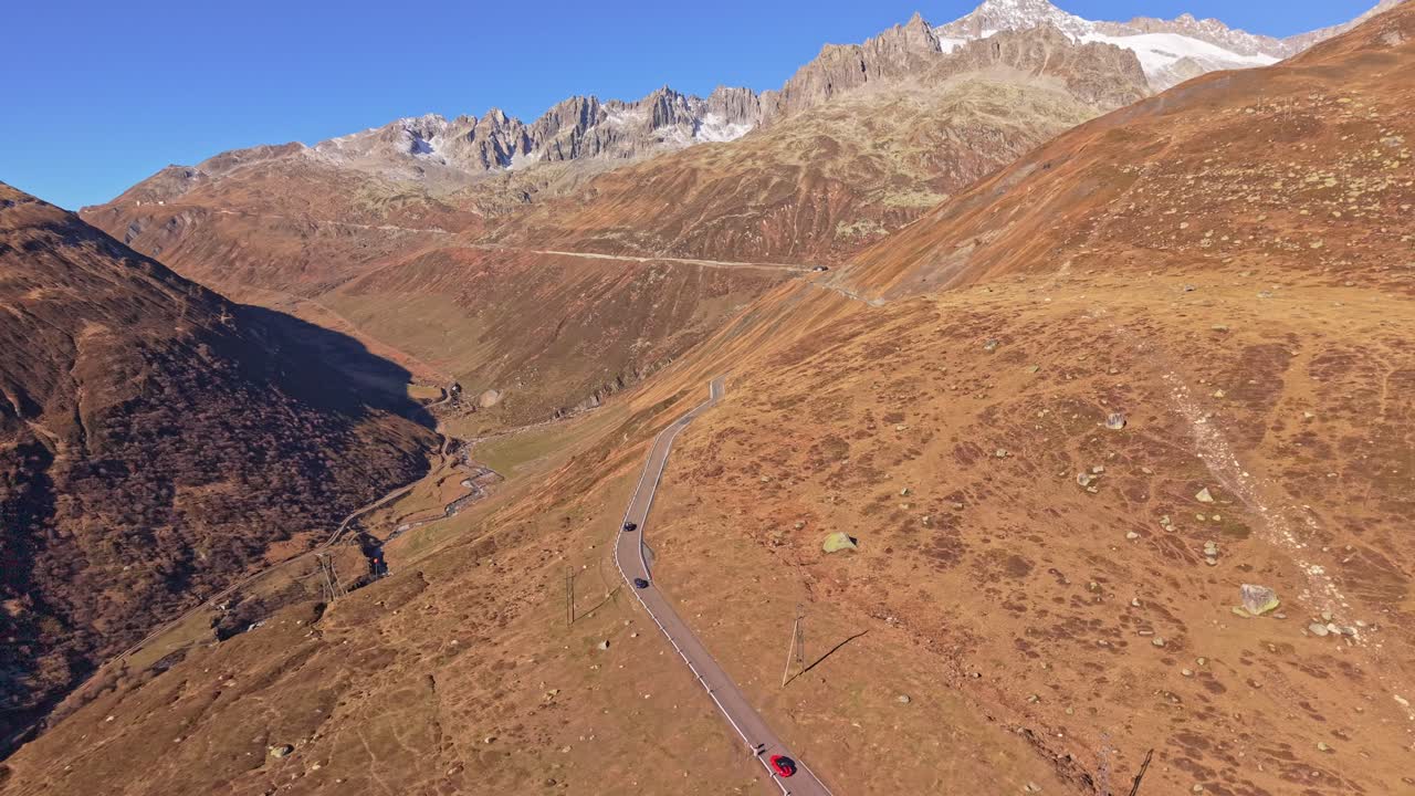 Aerial view of supercars cruising Furka Pass on a sunny day, Switzerland