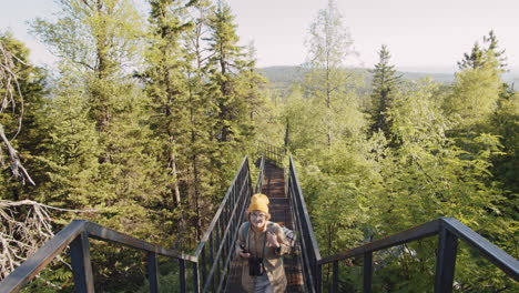 senior woman hiking on metal stairs in forest