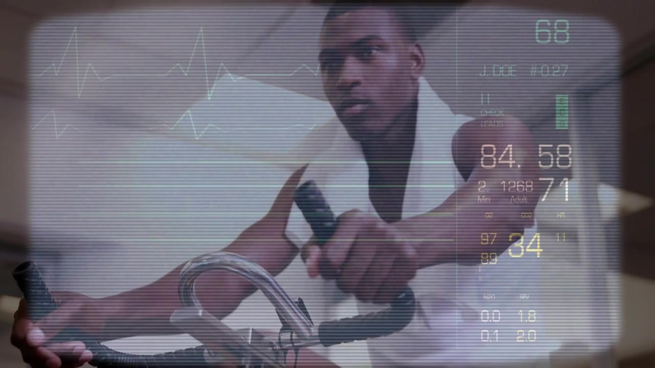 Vertical video: Man pedaling bike at gym wiping sweat with towel monitoring heart rate on HUD