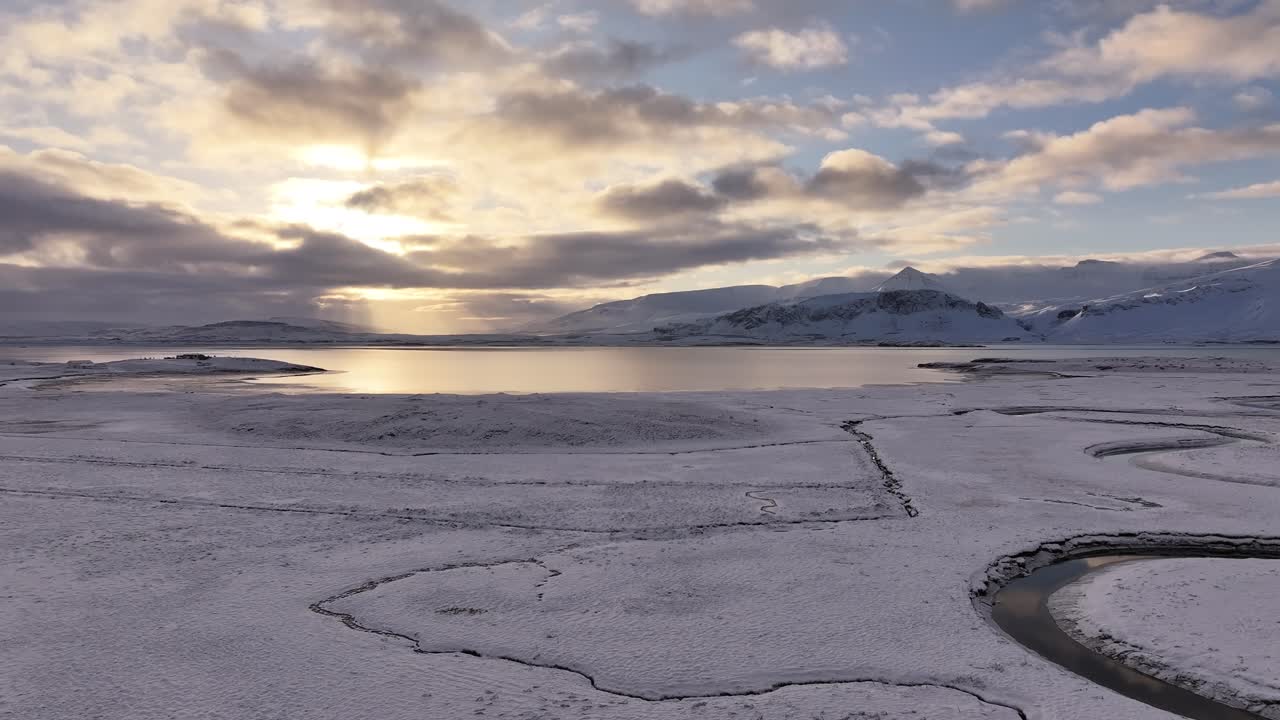 Aerial View of Frozen Lake Reflecting Sunlight in Borgarfjörður Mountains, Iceland – Winter Landscape