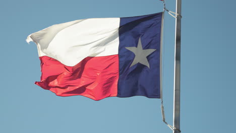 texas flag blowing and flapping in the wind on a flag pole in slow motion