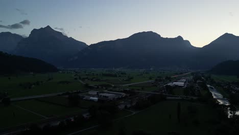 Clip-Aéreo-Del-Lago-En-El-Valle-Alrededor-De-Los-Picos-De-Las-Altas-Montañas-Con-Una-Fuente-Y-Muchos-Deportes-Acuáticos