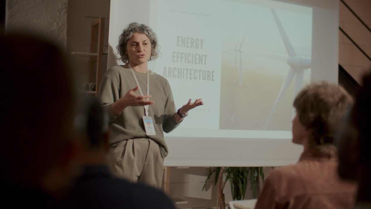 Relatrice che presenta architettura efficiente dal punto di vista energetico a una conferenza.