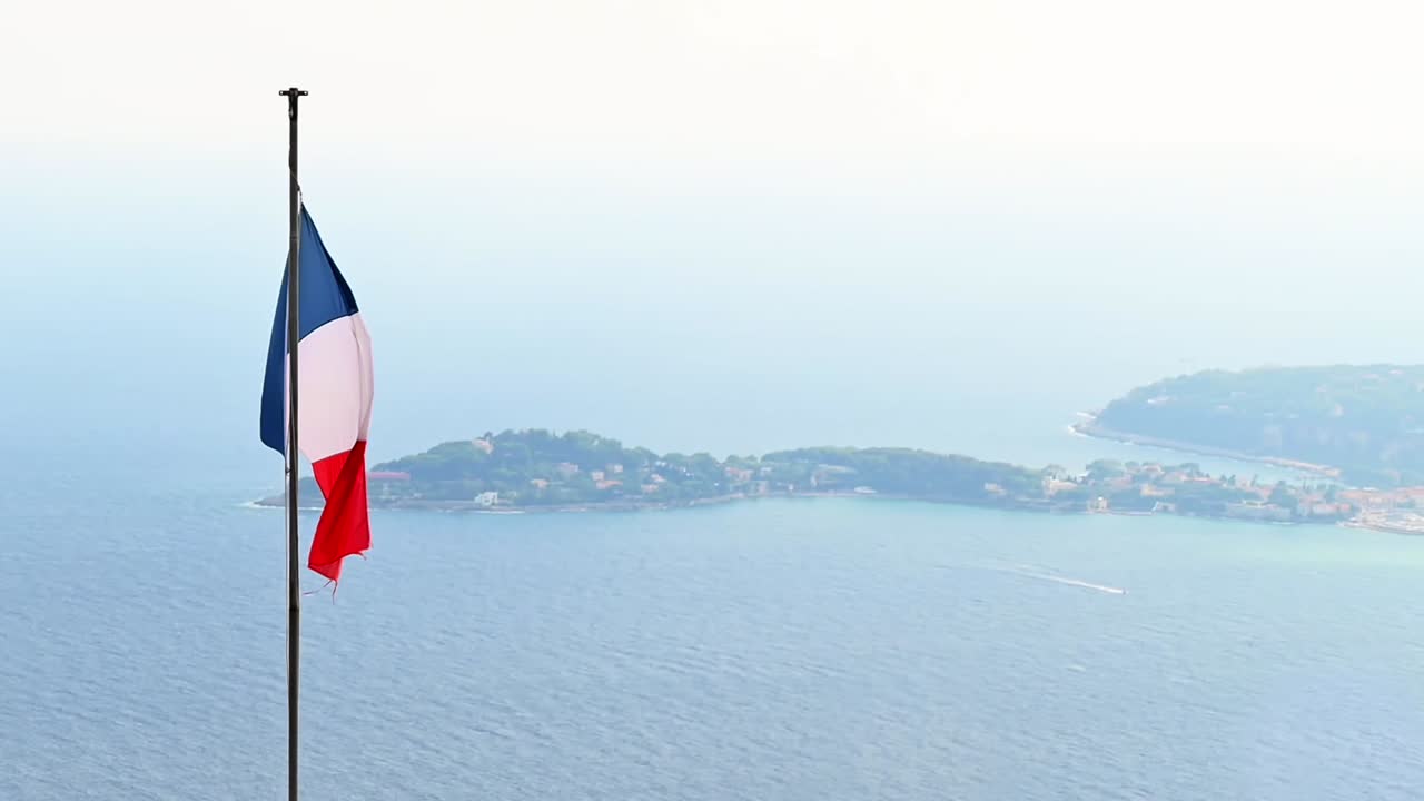 Roof with national flag, sea coast on the background in Menton, France. Slow motion