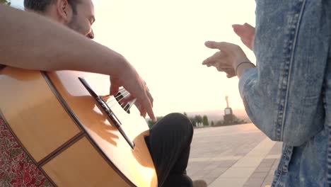 mujer irreconocible aplaudiendo al guitarrista masculino