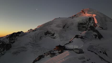 aerial view of a swiss alps summit during a sunrise, rocky and snowy mountains
