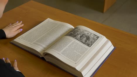 woman reading a large, open history book