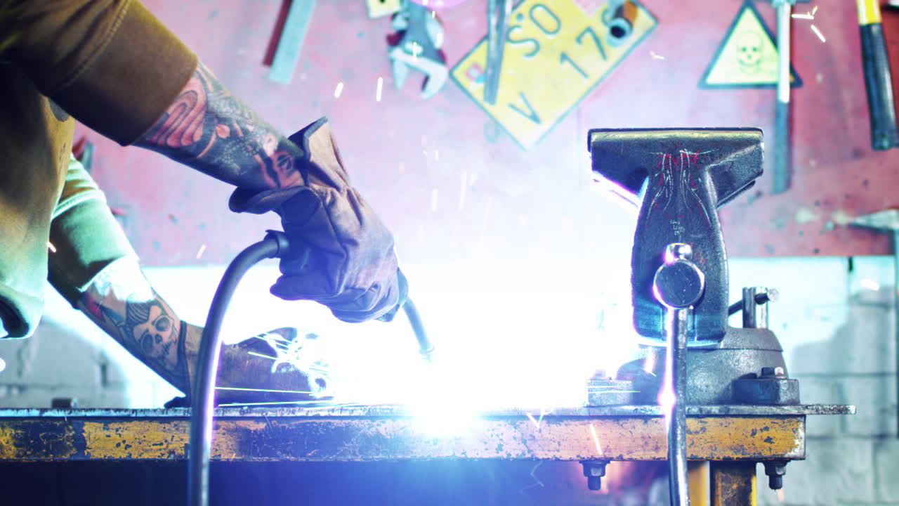 Metalworking industry. Close-up of worker welding metal at garage