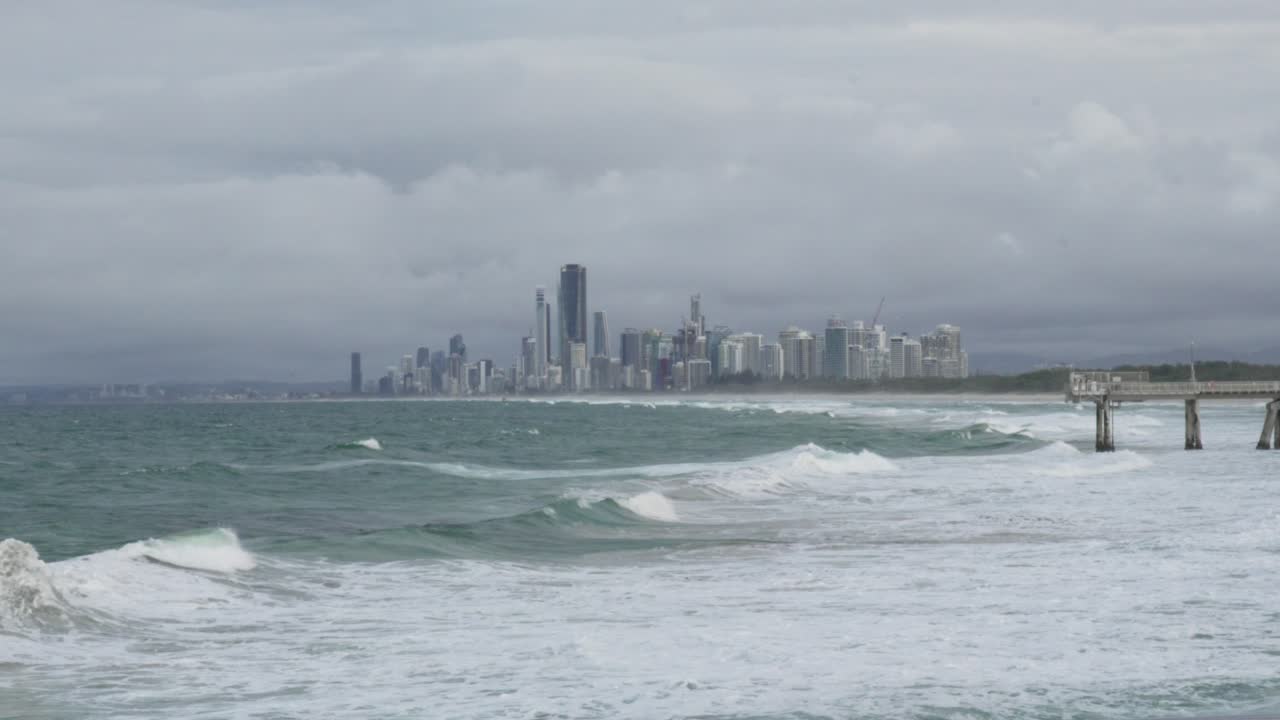 Stormy Seascape: City Skyline and Crashing Waves