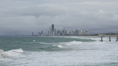 stormy seascape: city skyline and crashing waves