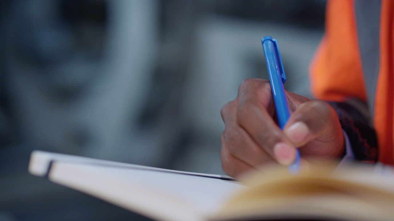 Analyst hands writing notes at factory closeup. Brown skin man use notebook