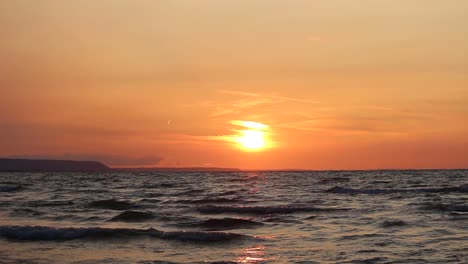 beach waves with a view of the sun setting.