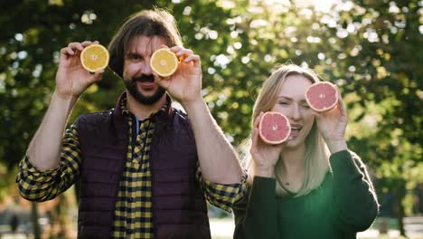 handheld view of couple making funny face with fruit eyes