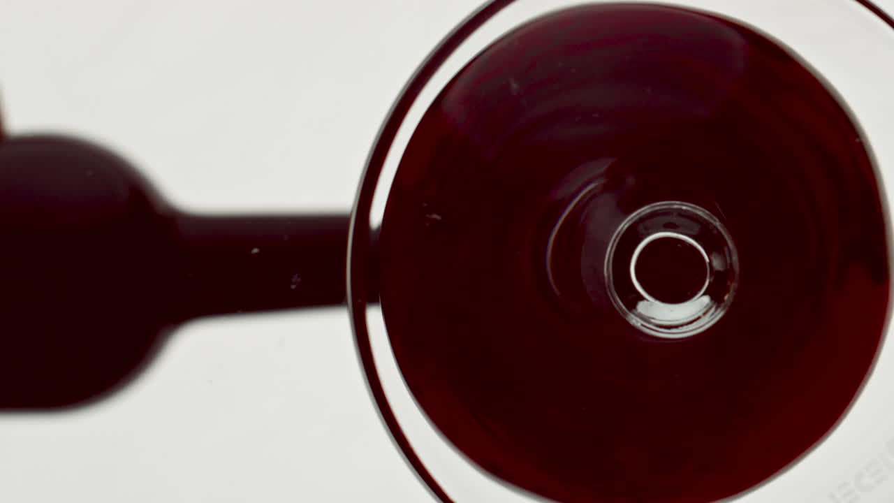 vista de abajo vaso de llenado de vino rojo. líquido alcohólico bordeaux dentro del vaso de vino
