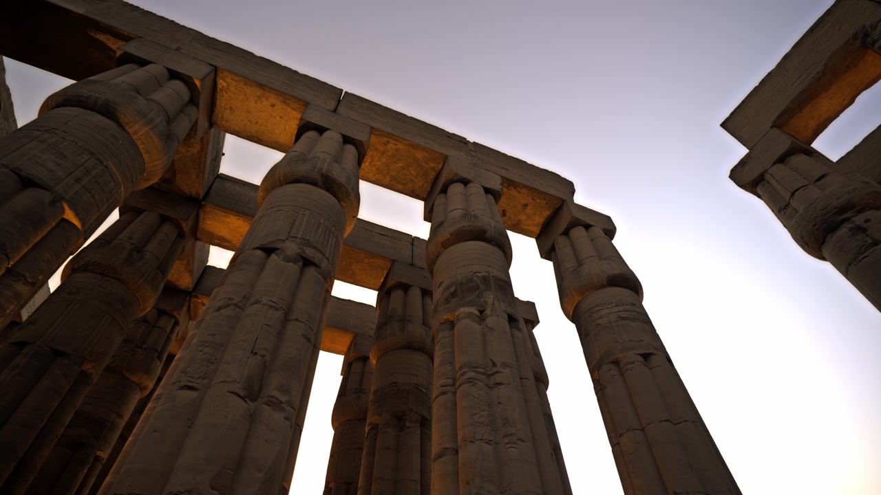 This clip showcases the Court of Amenhotep III at Luxor Temple during a vibrant sunset. The footage features the repetitive geometry of the papyrus-bundle columns and heavy architraves.