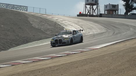 in slow motion at 60 fps, a sports car races down the track, its tires gripping the asphalt as it drifts smoothly through a tight corner.