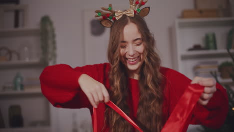mujer quitando la cinta de las cajas de regalos de navidad