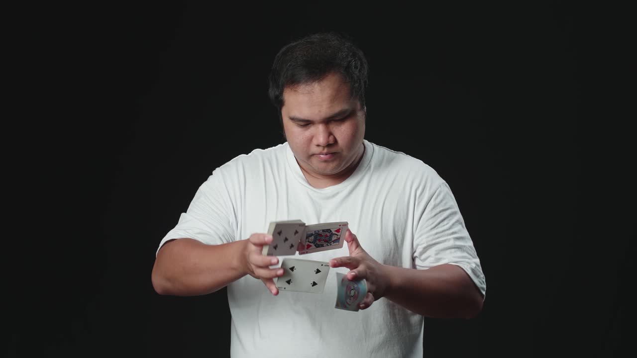 Asian Man Starts Showing His Trick With Cards, Cardistry On Black Background