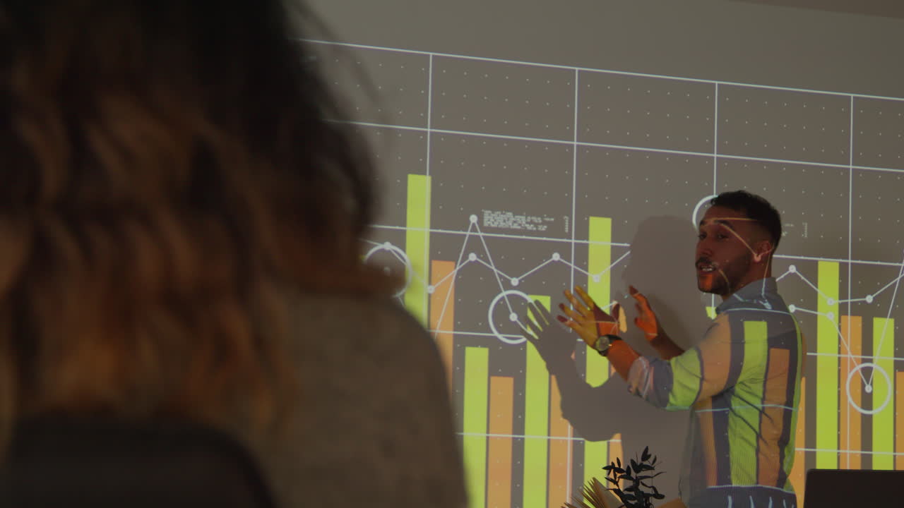 profesor masculino dando una lección de matemáticas o ciencias en una universidad o universidad de pie en la parte delantera de la clase con la proyección del gráfico 1