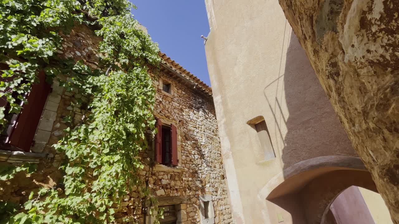 Bellissima vecchia casa in pietra ad Abt, in Francia, con molte piante verdi che spuntano.