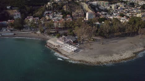 drone shot of a café on the beach beside a city