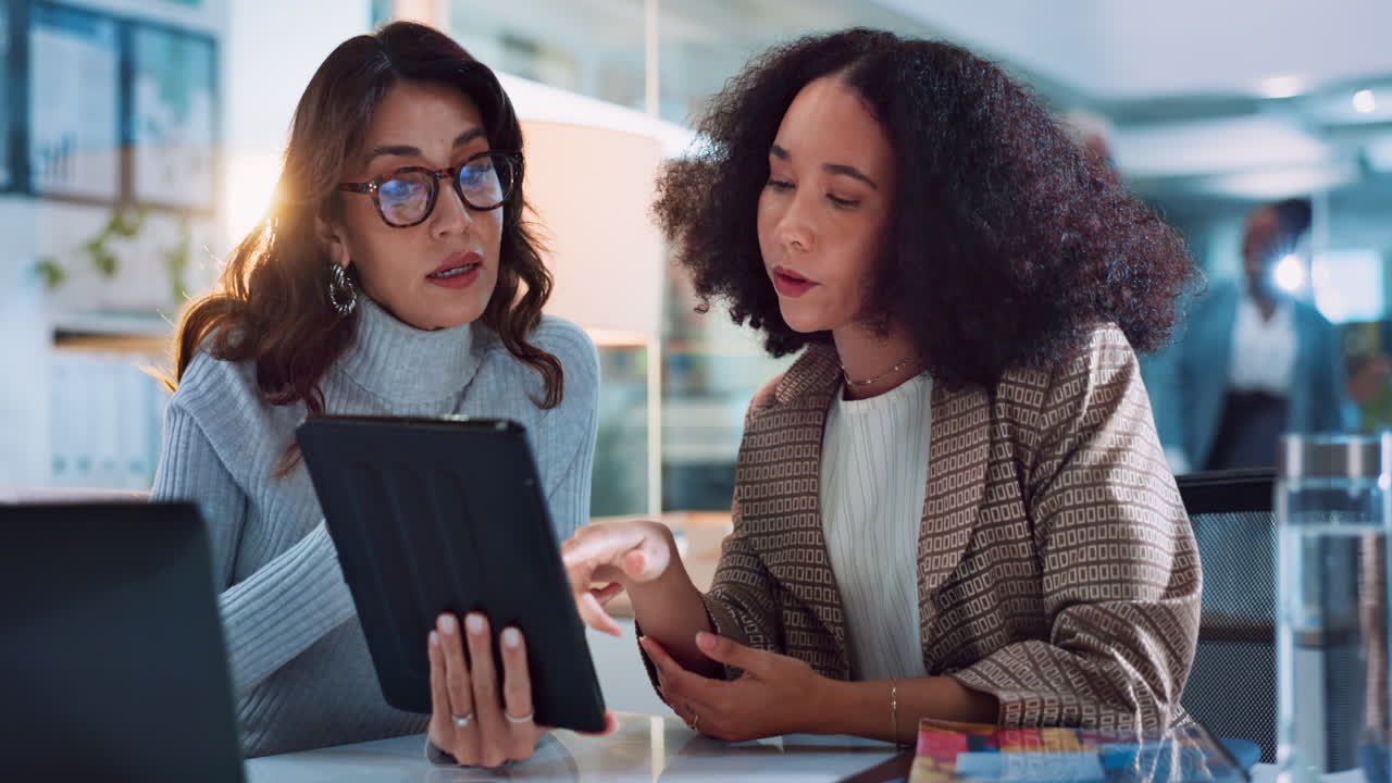 Businesswomen collaborating and discussing on a tablet
