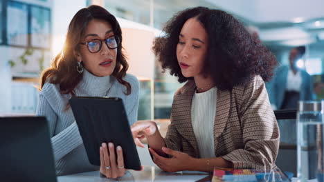 businesswomen collaborating and discussing on a tablet