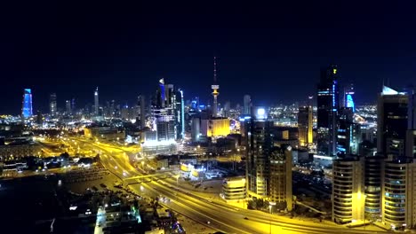 ascending forward dolly aerial shot of kuwait city at night. beautiful lit up cityscape in the middle east