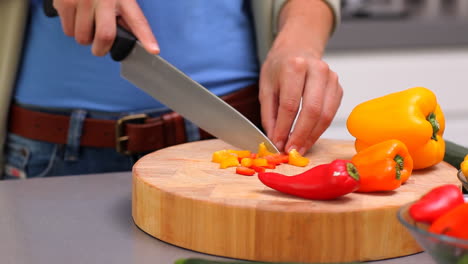 una mujer preparando pimientos.