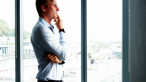 tensed executive standing near window