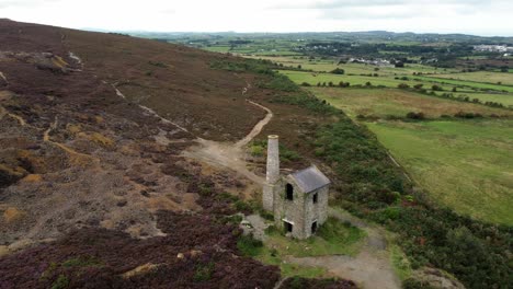 parys mountain abandoned brick chimney copper mining mill stone ruin aerial view slow forward descent