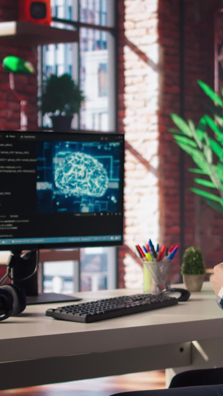 Vertical video AI engineer in home office stretching back while looking at PC screen, feeling fatigued